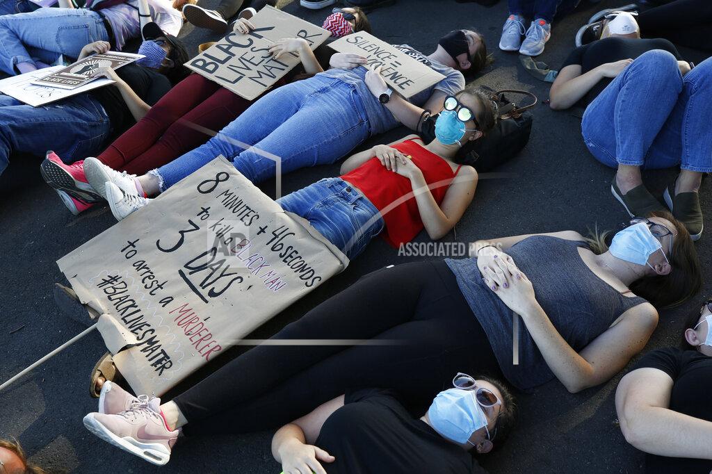 Rich Pedroncelli Protesters lay silent for 8 minutes and 46 seconds, Friday, June 5, 2020, during a demonstration to honor George Floyd, near the home of Sacramento Mayor Darrell Steinberg in Sacramento, Calif. Floyd died after being restrained by Minneapolis police officers on Memorial Day, May 25, 2020. (AP Photo/Rich Pedroncelli)