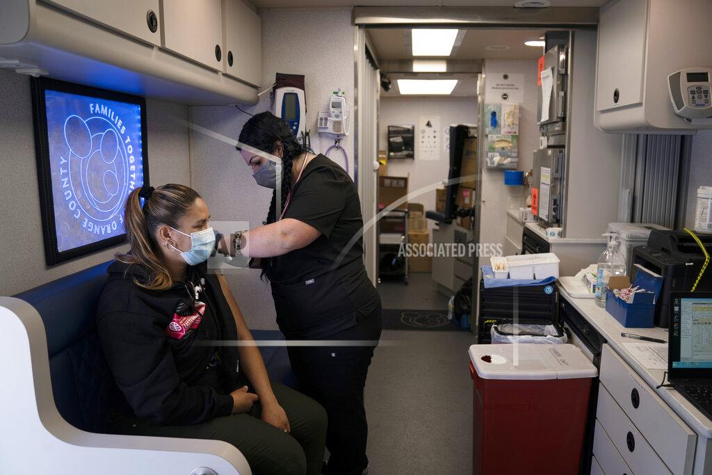 Nurse Natasha Garcia administers a dose of the Moderna COVID-19 vaccine to Monica Villalobos in a mobile clinic set up in the parking lot of a shopping center in Orange, Calif., Thursday, April 29, 2021. The mobile unit, launched in February by Families Together of Orange County, began its service to provide better access to the COVID-19 vaccine within the community and to prevent vaccine hesitation, according to mobile operations manager Parsia Jahanbani. (AP Photo/Jae C. Hong)