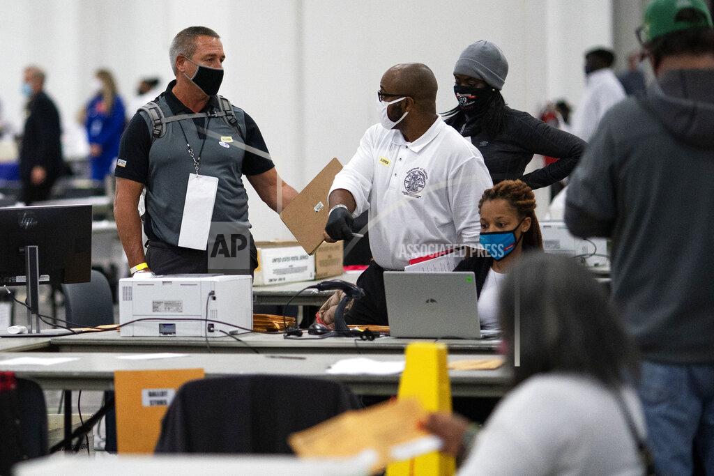 David Goldman A Republican election challenger at left talks with an election inspector as votes are counted into the early morning hours Wednesday, Nov. 4, 2020, at the central counting board in Detroit. (AP Photo/David Goldman)
