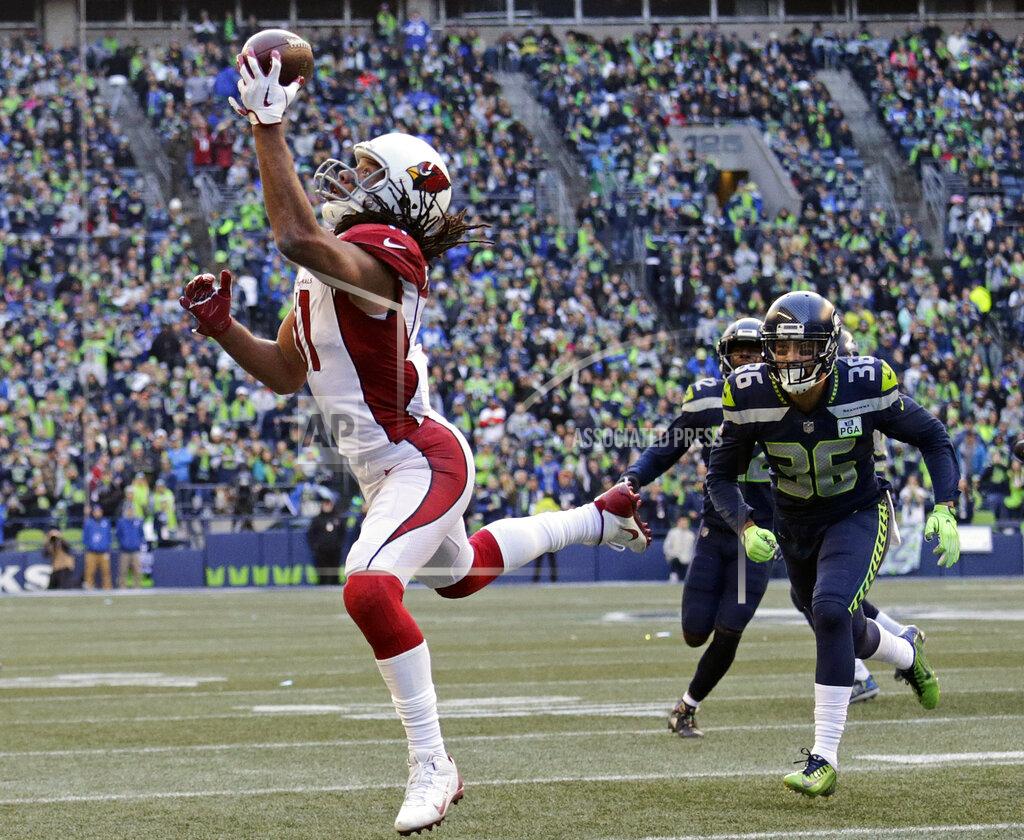 John Froschauer FILE - In this Dec. 30, 2018, file photo, Arizona Cardinals' Larry Fitzgerald, left, snags a one-handed touchdown pass against the Seattle Seahawks during the first half of an NFL football game, in Seattle. Star receiver Larry Fitzgerald is returning to the Arizona Cardinals for a 16th NFL season. The Cardinals announced Wednesday, Jan. 23, 2019, that they signed the 35-year-old Fitzgerald to a one-year contract. Team president Michael Bidwell says, “No player has meant more to this franchise or this community than Larry Fitzgerald.”(AP Photo/John Froschauer, File)