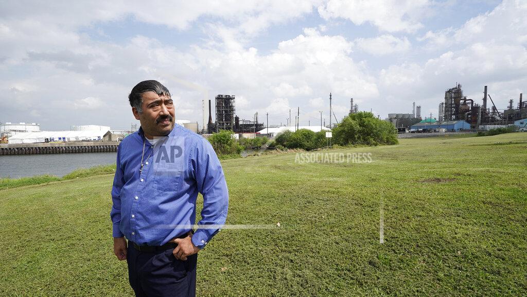 David J. Phillip Juan Flores stands in small park near a refinery along the Houston Ship Channel Monday, March 23, 2020, in Houston. Flores is working on a project to install air monitors at schools, not to warn children when the air was too bad to play outside, but alert them when plant emissions were low enough to make that safe. (AP Photo/David J. Phillip)