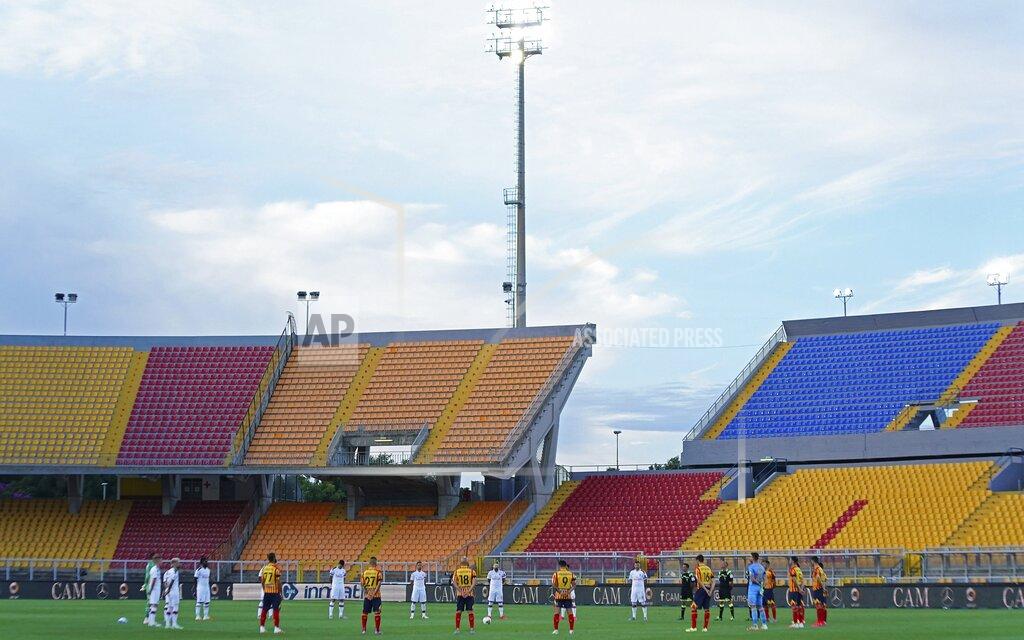 Spada Players observe a minute of silence to honor the victims of COVID-19 prior to the Serie A soccer match between Lecce and AC Milan, at the Via del Mare stadium in Lecce, Italy, Monday, June 22, 2020. (Spada/LaPresse via AP)