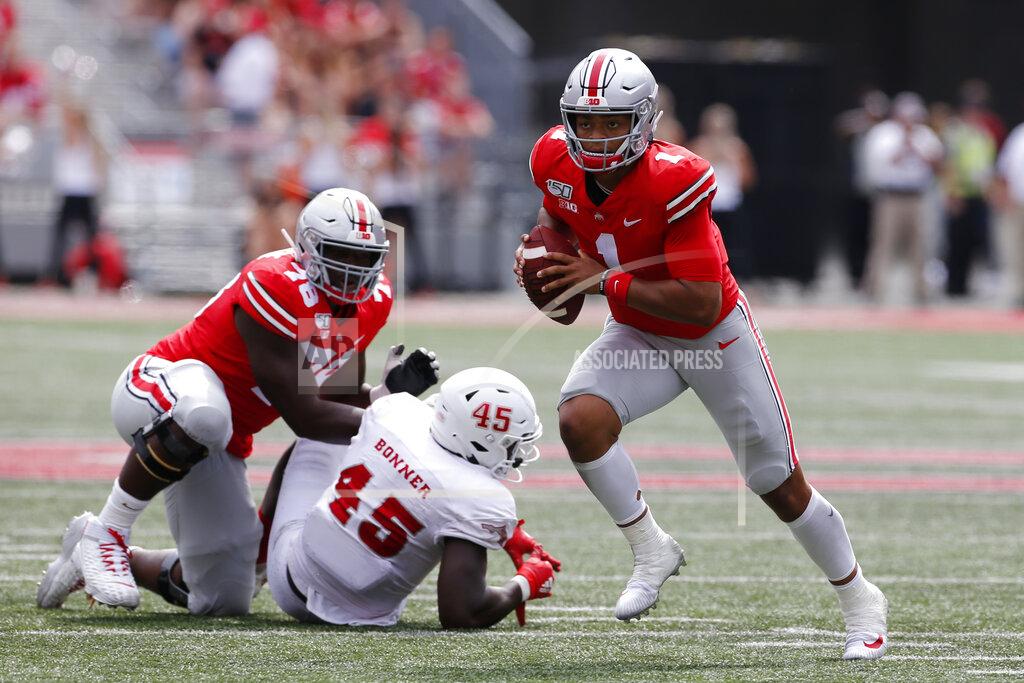 Jay Laprete Ohio State quarterback Justin Fields, right, runs up field as teammate Nicholas Petit-Frere, left, blocks Florida Atlantic defensive end Tim Bonner during the second half of an NCAA college football game Saturday, Aug. 31, 2019, in Columbus, Ohio. Ohio State beat Florida Atlantic 45-21. (AP Photo/Jay LaPrete)