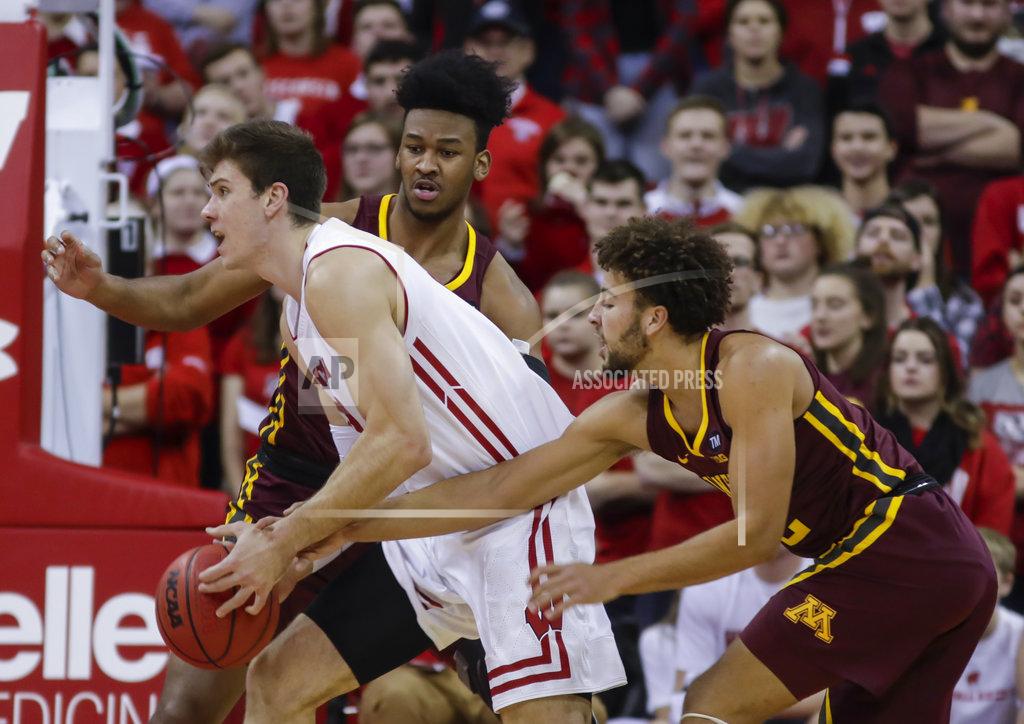 Andy Manis Wisconsin's Ethan Happ (22) drives against Minnesota's Eric Curry, behind, and Gabe Kalscheur, right, during the first half of an NCAA college basketball game Thursday, Jan. 3, 2019, in Madison, Wis. (AP Photo/Andy Manis)