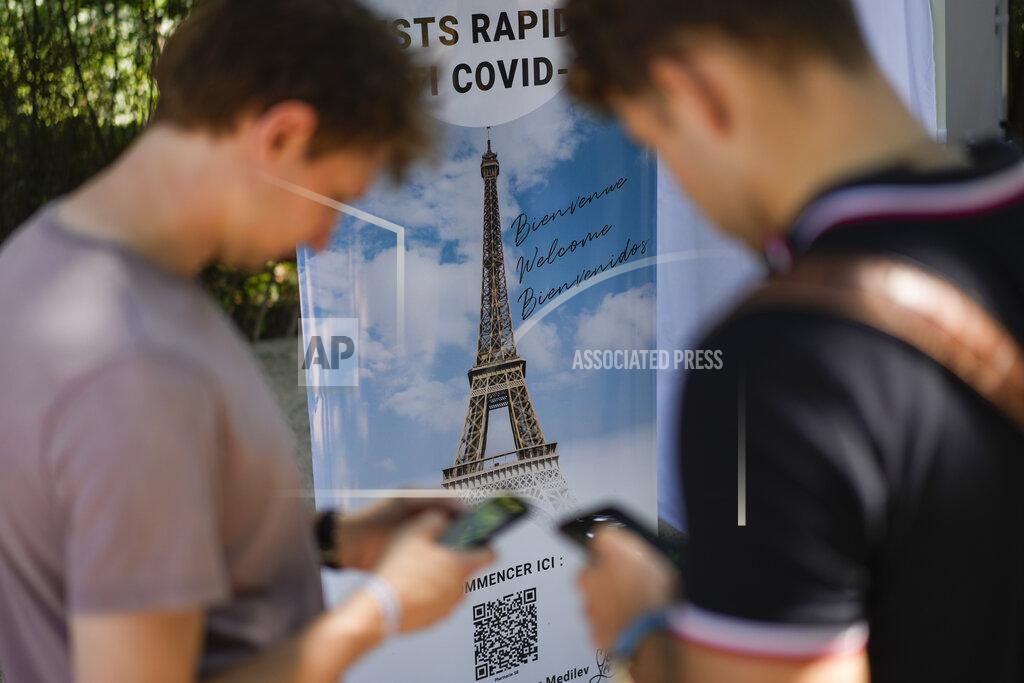 Daniel Cole FILE - In this Wednesday, July 21, 2021 file photo, visitors register for COVID-19 tests at the Eiffel Tower in Paris. For Europe’s battered tourism industry, fresh virus outbreaks and chaos and confusion over travel rules are contributing to a another cruel summer. With COVID-19 variants surging in parts of Europe, popular destination countries are taking measures to contain outbreaks. In France, the world's most visited country, visitors to cultural and tourist sites were confronted Wednesday, July 21, 2021 with a new requirement for a special COVID-19 pass. To get it, people must prove they're either fully vaccinated or recently recovered from an infection, or produce a negative virus test. (AP Photo/Daniel Cole, File)