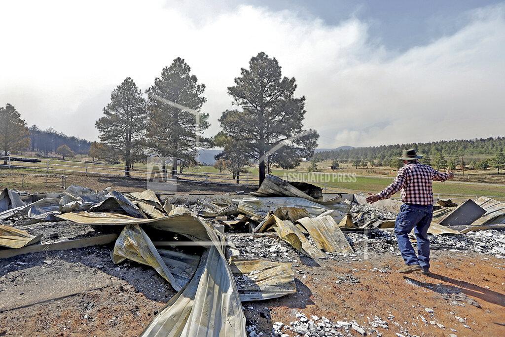 Luis Sanchez Saturno Jerry Gomez looks through the remains of his home following a wildfire in Rociada, New Mexico, on Tuesday, May 10, 2022. The largest wildfire burning in the United States was heading toward mountain resort towns in northern New Mexico on Wednesday, prompting officials to issue another set of warnings for more people to prepare to evacuate as the fast-moving fire picks up momentum. Gomez is enthusiastic about re-building. (Luis Sanchez Saturno/The New Mexican via AP)