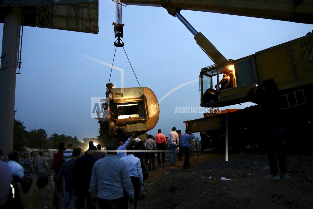 Fadel Dawood A crane is used to lift a part of a passenger train that derailed injuring around 100 people, near Banha, Qalyubia province, Egypt, Sunday, April 18, 2021. At least eight train wagons ran off the railway, the provincial governor's office said in a statement. (AP Photo/Fadel Dawood)