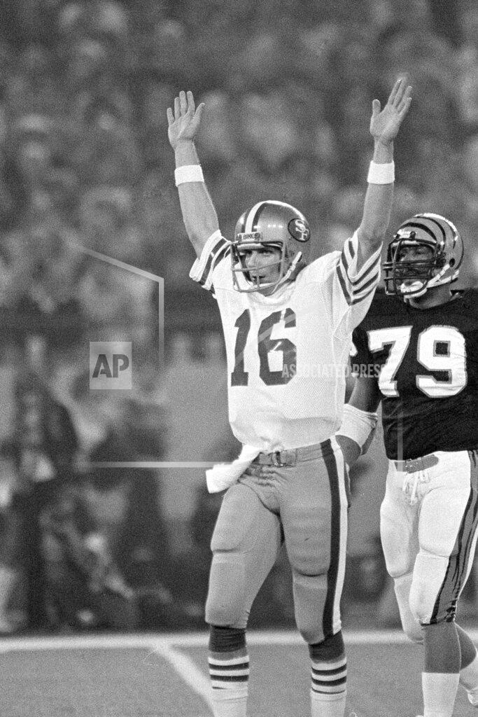 Anonymous FILE - In this Jan. 24, 1982, file photo, San Francisco 49ers quarterback Joe Montana signals a touchdown after throwing a pass to running back Earl Cooper in the second quarter of Super Bowl XVI against the Cincinnati Bengals in Pontiac, Mich., as Bengals' Ross Browner (79) looks on. (AP Photo/File)