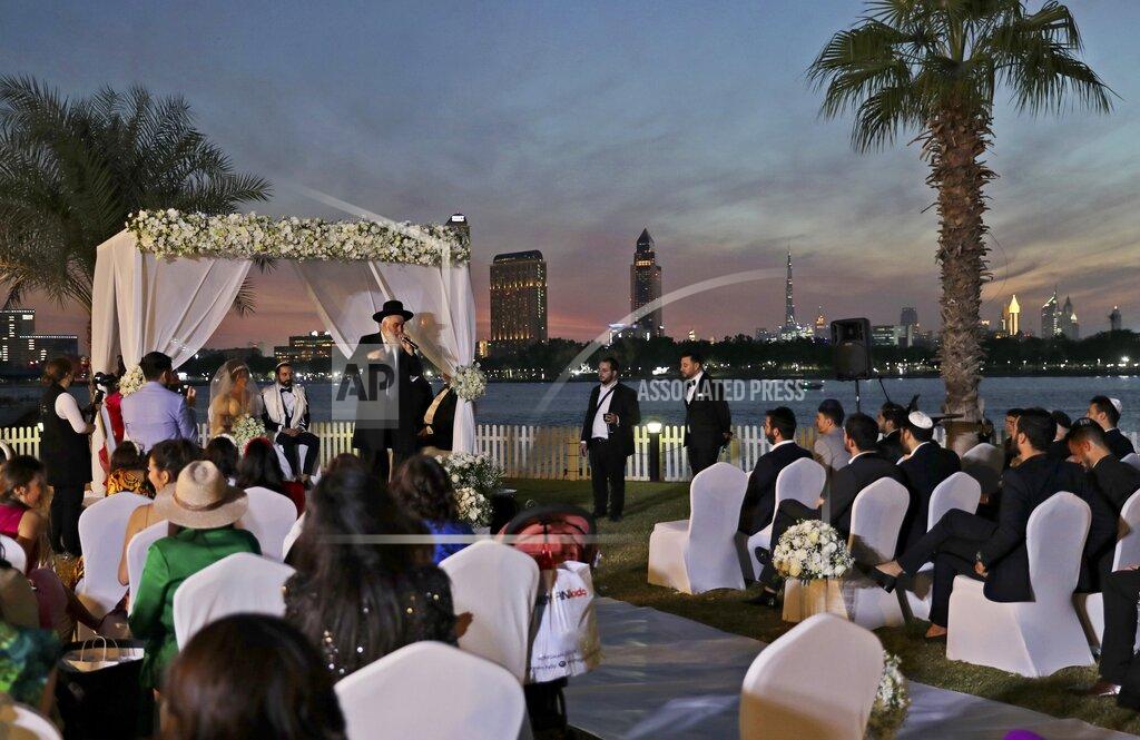 A rabbi officiates under a traditional Jewish wedding canopy during marriage ceremony of the Israeli couple Noemie Azerad, left sited under the canopy, and Simon David Benhamou, at a hotel in Dubai, United Arab Emirates, Thursday, Dec. 17, 2020. For the past month, Israelis long accustomed to traveling incognito, if at all, to Arab countries, have made themselves at home in the UAE’s commercial hub.(AP Photo/Kamran Jebreili)