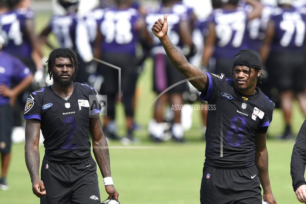 Baltimore Ravens quarterback Lamar Jackson, right, gives a thumbs up after an NFL football practice, Monday, Aug. 9, 2021 in Owings Mills, Md. Also pictured is Tyler Huntley. (AP Photo/Gail Burton)