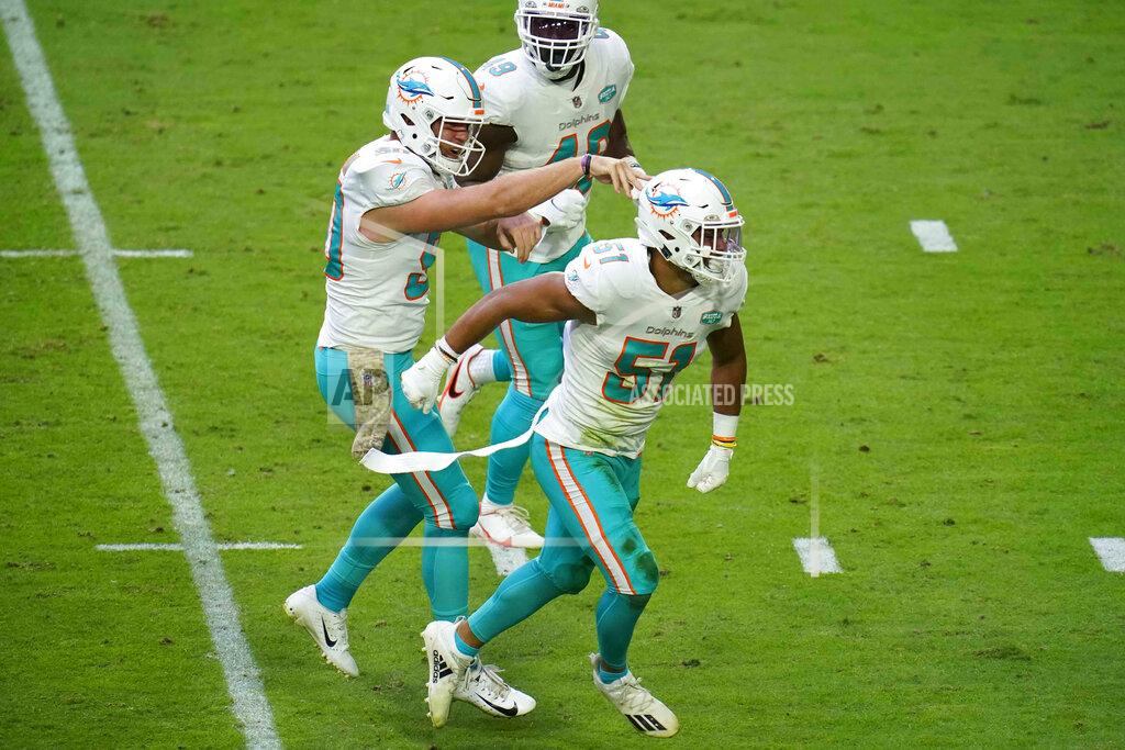 Ross D. Franklin Miami Dolphins outside linebacker Kamu Grugier-Hill (51) celebrates a defensive stop with defensive end Shaq Lawson, left, and linebacker Sam Eguavoen (49) during the first half of an NFL football game against the Arizona Cardinals, Sunday, Nov. 8, 2020, in Glendale, Ariz. (AP Photo/Ross D. Franklin)