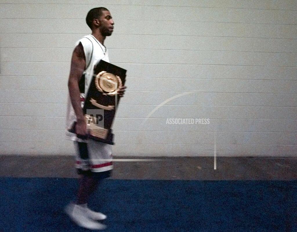 Ed Reinke FILE - In this March 29, 1999, file photo, Connecticut's Richard Hamilton carries the NCAA college basketball championship trophy after participating in a news conference following the Final Four championship game at Tropicana Field in St. Petersburg, Fla. UConn defeated Duke 77-74. (AP Photo/Ed Reinke, File)