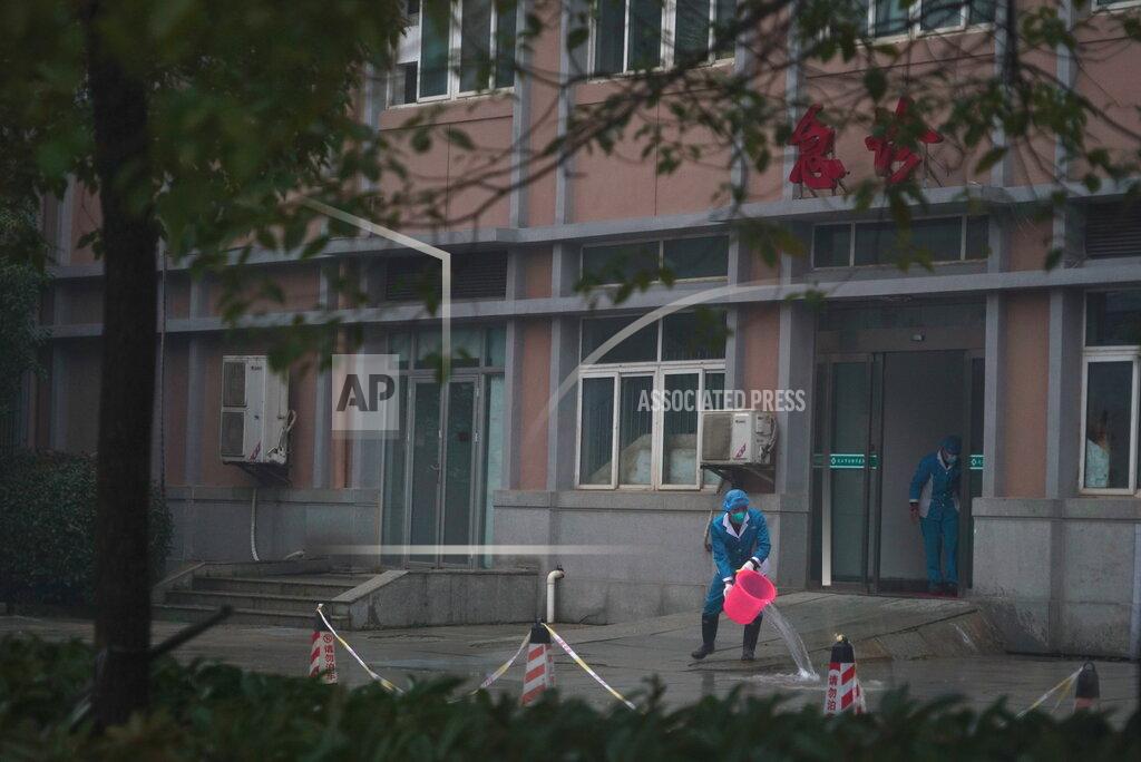 FILE - In this Wednesday, Jan. 22, 2020 file photo, hospital staff wash the emergency entrance of Wuhan Medical Treatment Center, where some infected with a new virus are being treated, in Wuhan, China. A panel of experts commissioned by the World Health Organization has criticized China and other countries for not moving to stem the initial outbreak of the coronavirus earlier and questioned whether the U.N. health agency should have labeled it a pandemic sooner. (AP Photo/Dake Kang, File)
