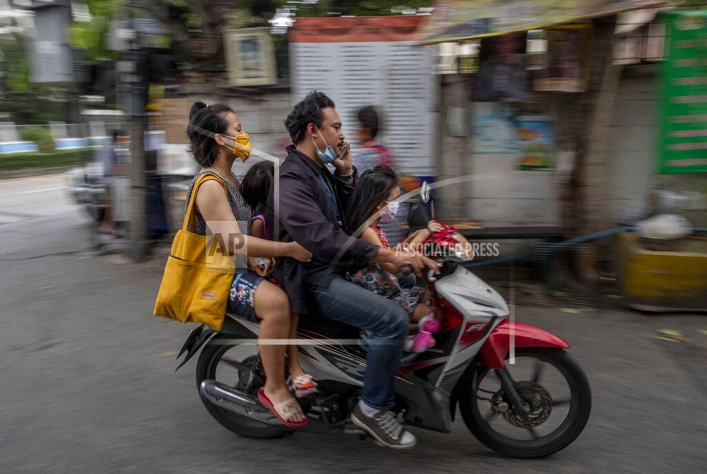 Gemunu Amarasinghe A Thai family of four, wearing face masks travel in a motorbike in Bangkok, Thailand, Thursday, April 16, 2020. A month-long state of emergency remain enforced in Thailand to allow its government to impose stricter measures to control the coronavirus that has infected hundreds of people in the Southeast Asian country. (AP Photo/Gemunu Amarasinghe)