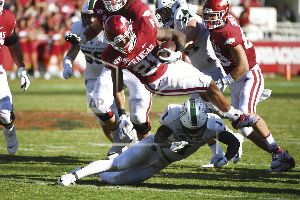 Michael Woods Arkansas running back Devwah Whaley is tripped up by Portland State defender Romeo Gunt during the second half of an NCAA college football game Saturday, Aug. 31, 2019 in Fayetteville, Ark. (AP Photo/Michael Woods)