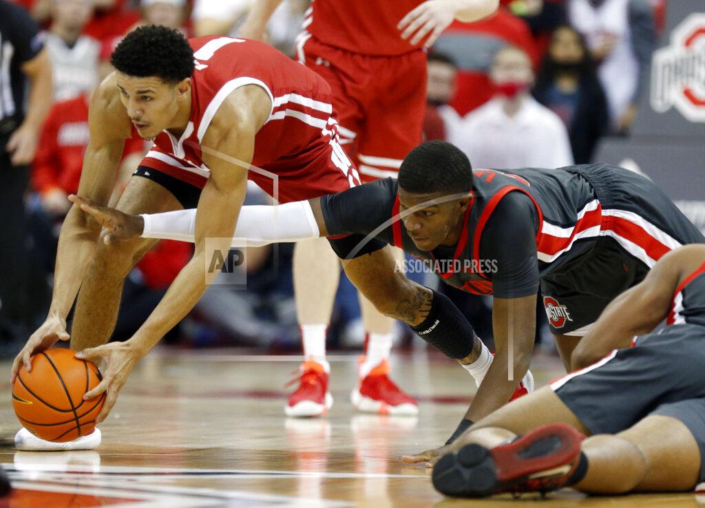 Paul Vernon Wisconsin guard Jonathan Davis, left, and Ohio State forward E.J. Liddell reach for a loose ball during the first half of an NCAA college basketball game in Columbus, Ohio, Saturday, Dec. 11, 2021. (AP Photo/Paul Vernon)