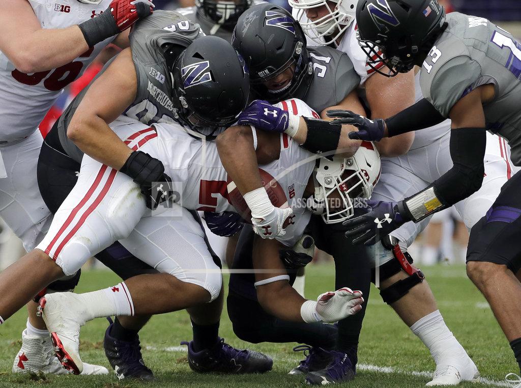 In this Oct. 27, 2018 photo Wisconsin running back Jonathan Taylor is tackled by Northwestern defenders during the first half of an NCAA college football game in Evanston, Ill. Taylor had his worst game of the season for Wisconsin, leaving his race for the national rushing lead with Memphis Darrell Henderson in a virtual dead heat two-thirds of the way through the season. (AP Photo/Nam Y. Huh)