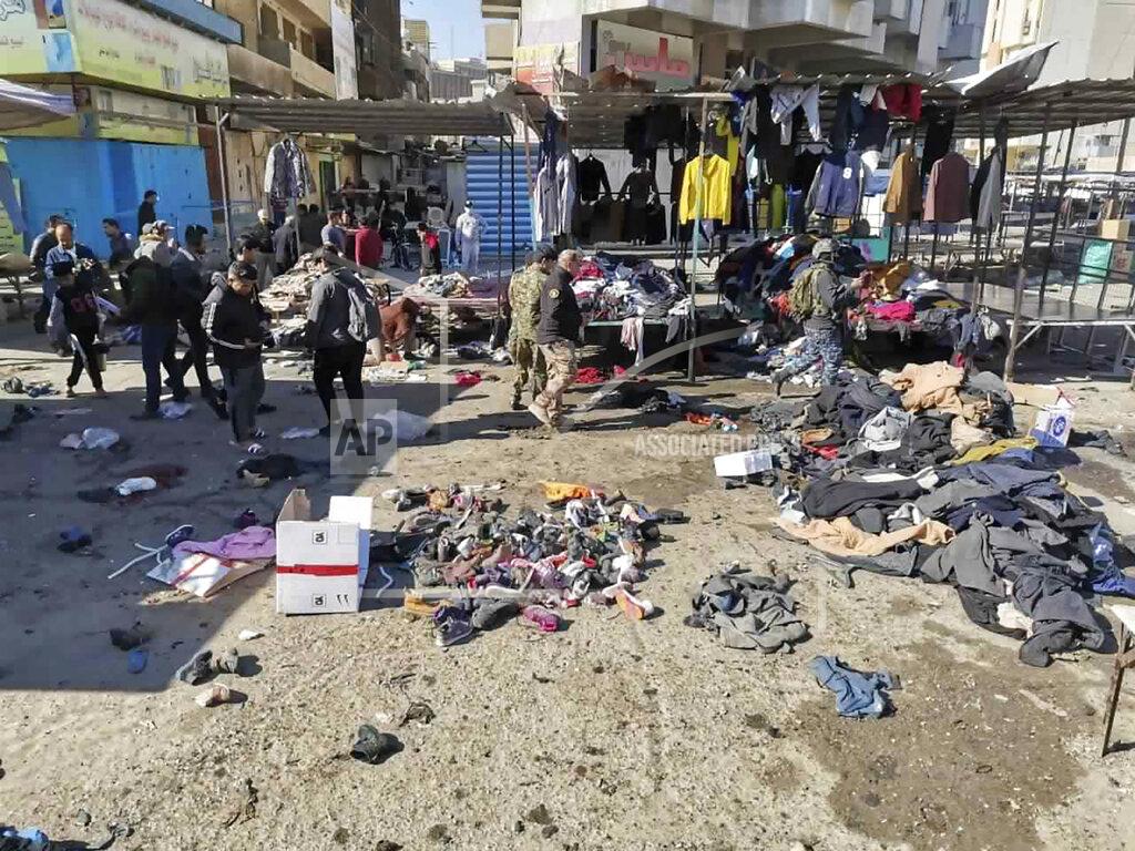 Hadi Mizban People and security forces gather at the site of a deadly bomb attack in a market selling used clothes, Iraq, Thursday, Jan. 21, 2021. Twin suicide bombings hit Iraq's capital Thursday killing and wounding civilians, police and state TV said. (AP Photo/Hadi Mizban)