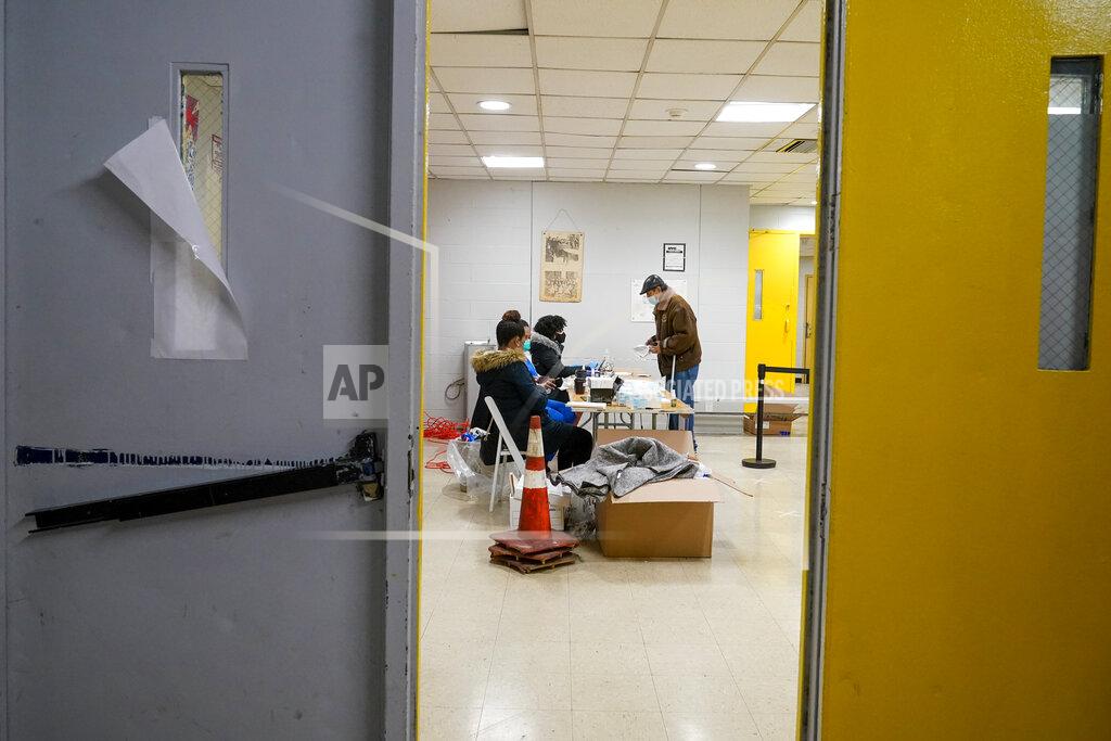 Mary Altaffer Jesus Rodriguez, right, registers for the first dose of the coronavirus vaccine at a COVID-19 vaccination site at the Corsi Houses, Friday, Jan. 15, 2021, in the East Harlem neighborhood of New York. From elderly Cuban Americans in Florida to farmworkers in California, Latinos face daunting barriers like fear, language and a lack of education and access as the COVID-19 vaccines roll out, creating risks for public health as the virus mutates and spreads. (AP Photo/Mary Altaffer)