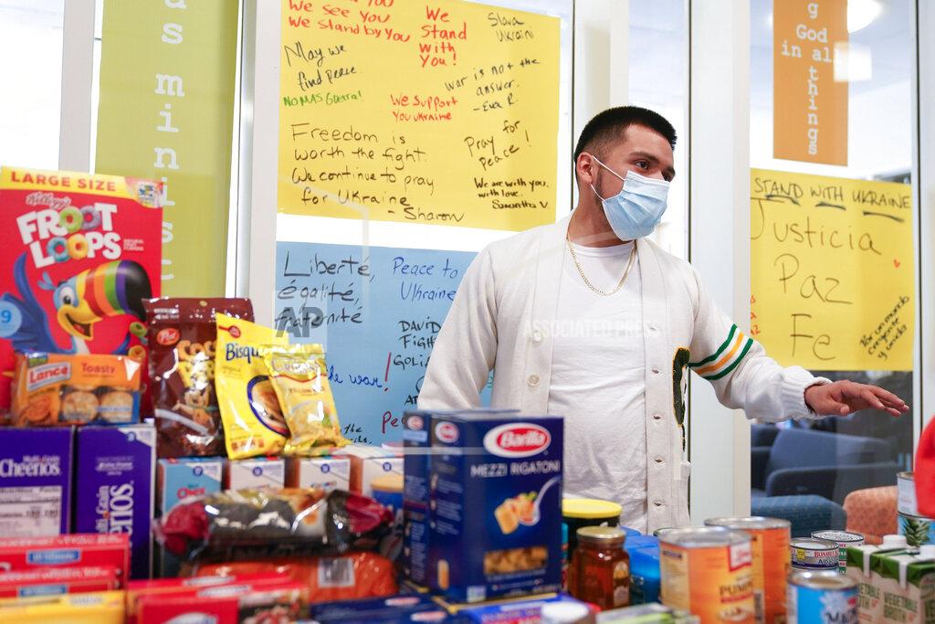 Seth Wenig Student Evaristo Solano-Lopez organizes items donated to food drive at St. Peter's University in Jersey City, N.J., Monday, March 21, 2022. (AP Photo/Seth Wenig)