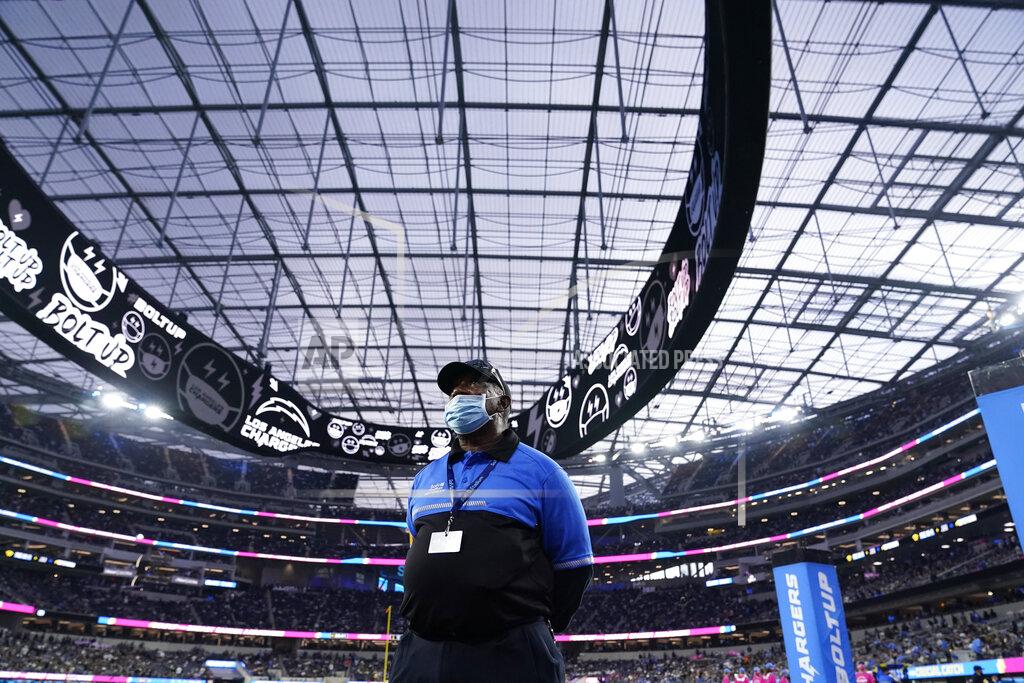 Marcio Jose Sanchez An official at SoFi Stadium looks on during a weather delay shortly before the scheduled start of an NFL football game between the Los Angeles Chargers and the Las Vegas Raiders, Monday, Oct. 4, 2021, in Inglewood, Calif. (AP Photo/Marcio Jose Sanchez)