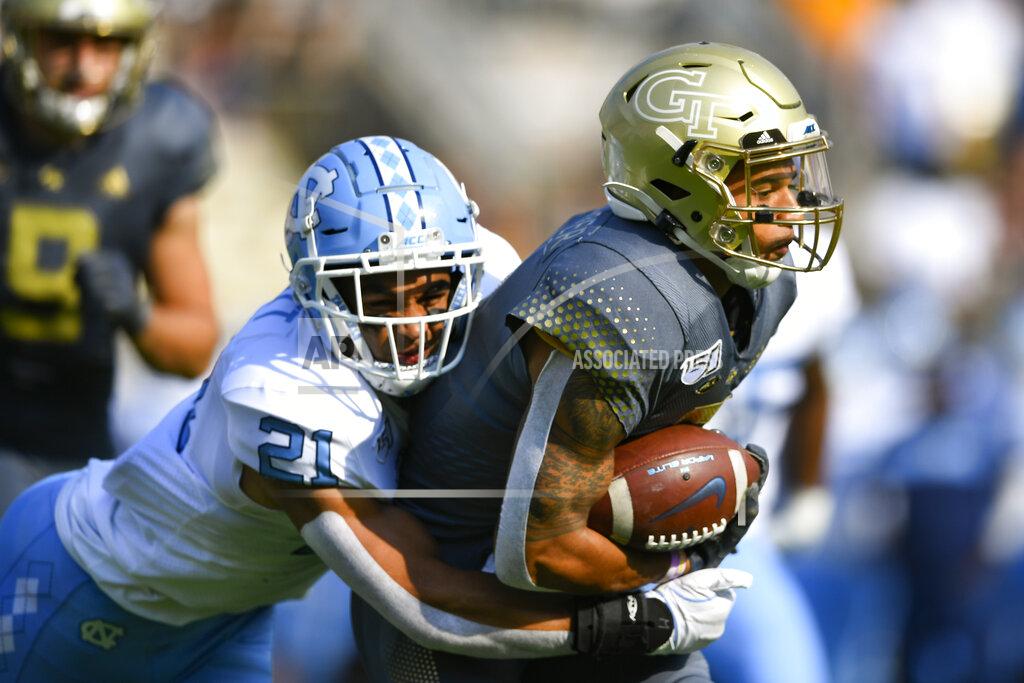 John Amis Georgia Tech's Tobias Oliver (8) runs with the ball as North Carolina linebacker Chazz Surratt (21) tackles during the first half of an NCAA college football game Saturday, Oct. 5, 2019, in Atlanta. (John Amis/Atlanta Journal-Constitution via AP)