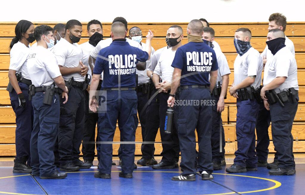 Steve Ruark Baltimore city police instructors speak to police trainees during defense tactic training, Wednesday, Aug. 4, 2021, in Baltimore. Baltimore's police force is struggling to meet staffing targets to fully comply with a reform intervention and get out from under federal oversight. The agency has some 400 vacancies among its sworn staff and its recruitment efforts just can’t keep pace with those leaving their jobs. (AP Photo/Steve Ruark)
