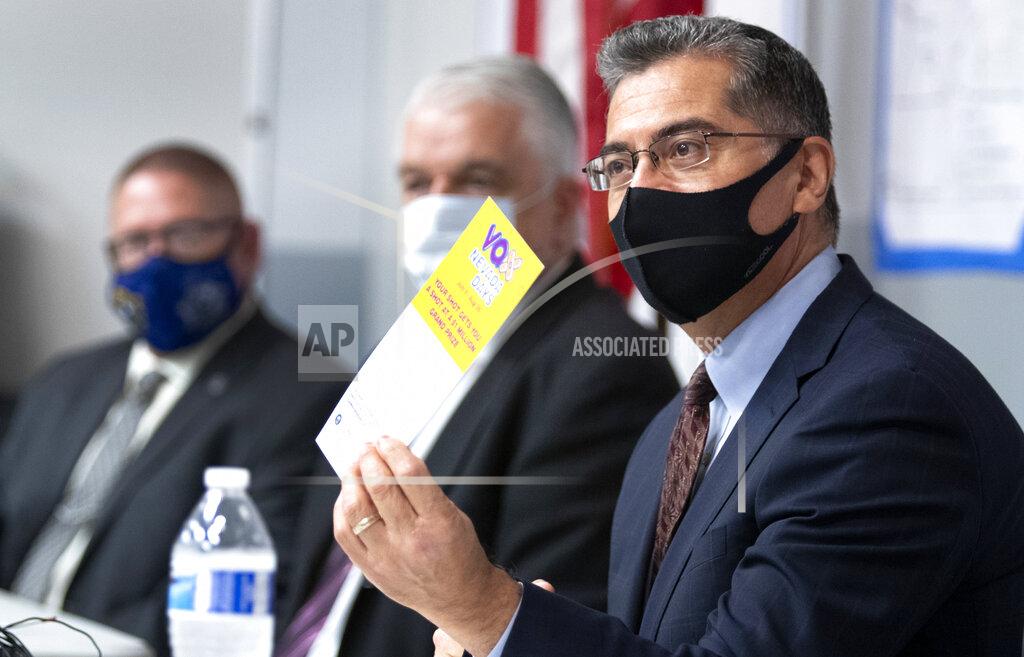 Steve Marcus FILE - In this July 22, 2021 file photo, U.S. Department of Health and Human Services (HHS) Secretary Xavier Becerra holds up a flier promoting the Vax Nevada Days lottery after briefing from officials at the Clark County Fire Department Training Facility in Las Vegas. Most Americans who haven’t been vaccinated against COVID-19 say they are unlikely to get the shots and doubt they would work against the aggressive delta variant despite evidence they do, according to a new poll that underscores the challenges facing public health officials amid soaring infections in some states. (Steve Marcus /Las Vegas Sun via AP)