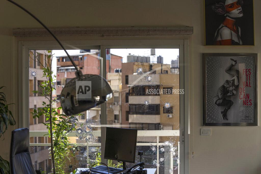 Hassan Ammar An office window is riddled with bullet holes after the deadly clashes that erupted last Thursday along a former 1975-90 civil war front-line between Muslim Shiite and Christian areas, in Ain el-Rumaneh neighborhood, Beirut, Lebanon, Tuesday, Oct. 19, 2021. The shootout on the streets of Beirut between rival Christian and Muslim groups has revived memories of the country's 1975-90 civil war and fired up sectarian passions in a country that never dealt with the causes of its violent past. (AP Photo/Hassan Ammar)