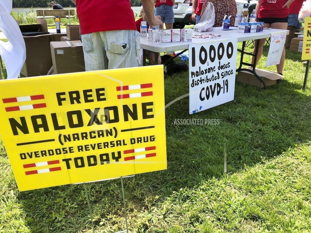 John Raby FILE - Signs are displayed at a tent during a health event on June 26, 2021, in Charleston, W.Va. A federal judge on Monday, July 4, 2022, ruled in favor of three major U.S. drug distributors in a landmark lawsuit that accused them of causing a health crisis in one West Virginia county ravaged by opioid addiction. (AP Photo/John Raby, File)