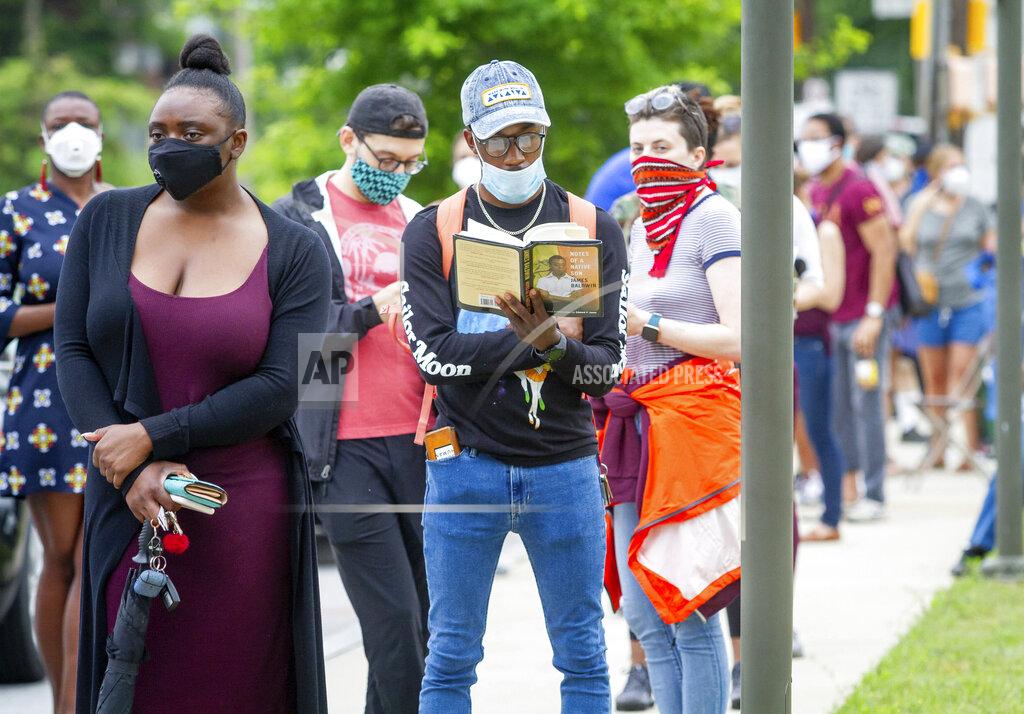 Steve Schaefer Voters wait in a line that stretched around the Metropolitan Library in Atlanta, Georgia, Tuesday, June 9, 2020. (Steve Schaefer/Atlanta Journal-Constitution via AP)