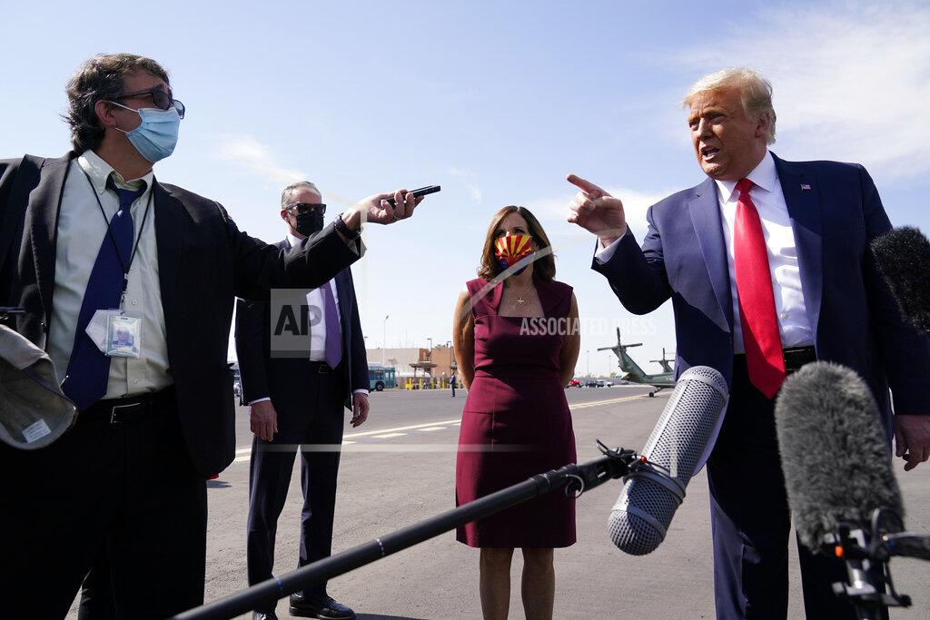 Alex Brandon President Donald Trump talks to reporters at Phoenix Sky Harbor International Airport, Monday, Oct. 19, 2020, in Phoenix. Second from right is Sen. Martha McSally, R-Ariz. (AP Photo/Alex Brandon)