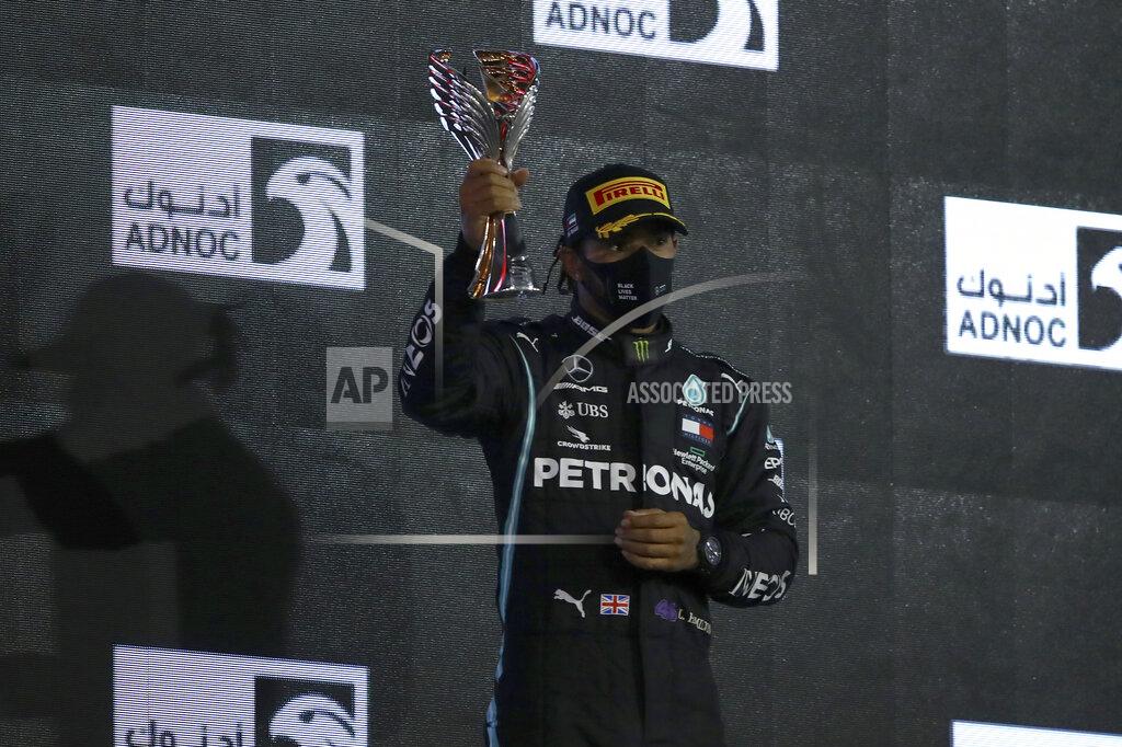 Brynn Lennon World champion Mercedes driver Lewis Hamilton of Britain celebrates on the podium after the Formula One race in the Yas Marina racetrack in Abu Dhabi, United Arab Emirates, Sunday, Dec.13, 2020. (Brynn Lennon, Pool via AP)