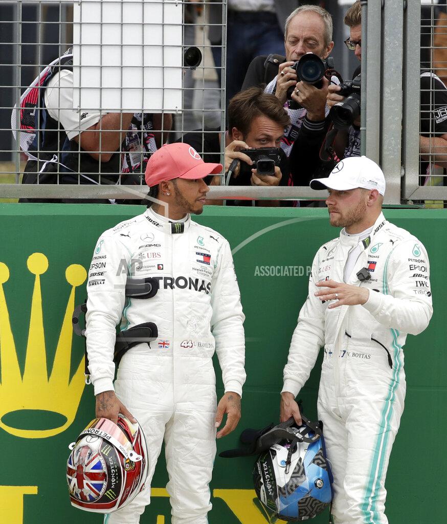 Luca Bruno Mercedes driver Valtteri Bottas of Finland, right, speaks with second placed Mercedes driver Lewis Hamilton of Britain after he clocked the fastest time during the qualifying session at the Silverstone racetrack, in Silverstone, England, Saturday, July 13, 2019. The British Formula One Grand Prix will be held on Sunday. (AP Photo/Luca Bruno)
