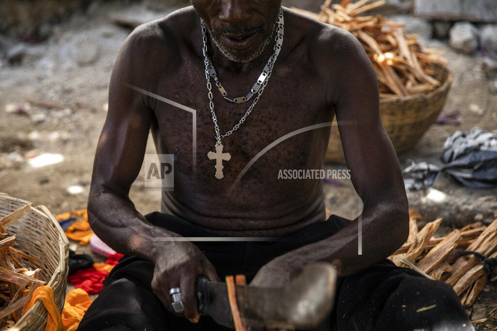 Rodrigo Abd A vendor prepares kindling outside his home in the La Piste neighborhood of Port-au-Prince, Haiti, Friday, Sept. 17, 2021. The wealthy of Port-au-Prince live in the hillside eastern suburb of Petion-Ville in gated and privately guarded homes, largely protected from the violence and cost of payoffs. But the poor suffer rising prices and bottlenecks. (AP Photo/Rodrigo Abd)