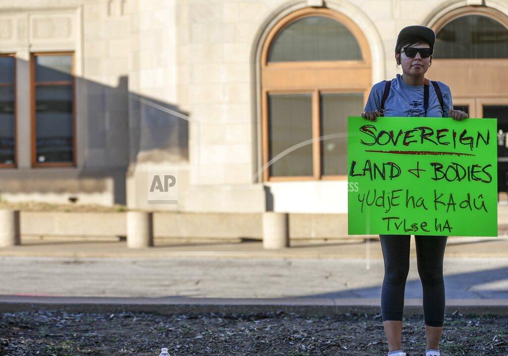 Manuela Soldi/Tulsa World Sasafane stands with sign made for protest in response to Supreme Court's ruling in Tulsa, Okla.,on Thursday, June 29, 2022. The Supreme Court has ruled that Oklahoma can prosecute non-Native Americans for crimes committed on tribal land when the victim is Native American. The 5-4 decision on Wednesday cut back on the high court’s ruling from 2020 that said a large chunk of eastern Oklahoma remains an American Indian reservation. (Manuela Soldi/Tulsa World via AP)