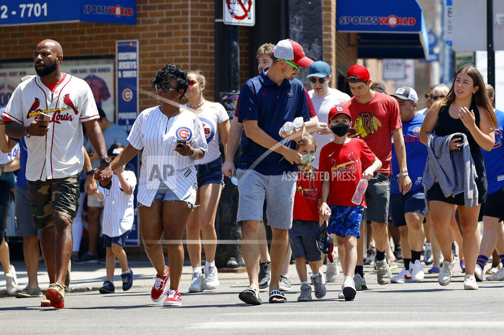 Shafkat Anowar People cross a street as they make their way towards Chicago's Wrigley Field during baseball game, Friday, June 11, 2021, as Chicago and rest of Illinois fully reopens ending an over a year-long COVID-19 restrictions. (AP Photo/Shafkat Anowar)