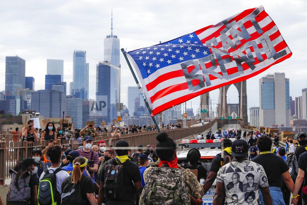 John Minchillo FILE - Protesters march on the Brooklyn Bridge, Thursday, June 4, 2020, in New York under a U.S. flag with the slogan "I can't breathe." Protests continued following the death of George Floyd, who died after being suffocated by Minneapolis police officers on May 25. (AP Photo/John Minchillo, File)