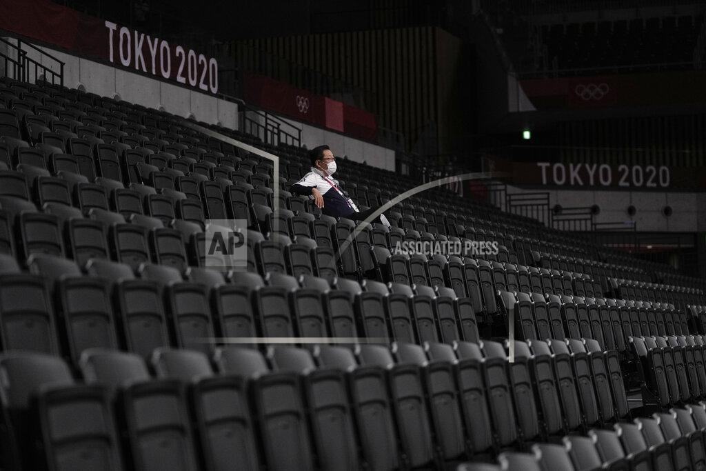 Manu Fernandez FILE - In this July 31, 2021, file photo, a man, wearing a protective face mask, sits inside an empty Ariake Arena, just before the start of a women's volleyball preliminary round pool A match between Japan and South Korea, at the 2020 Summer Olympics, in Tokyo, Japan. (AP Photo/Manu Fernandez, File)