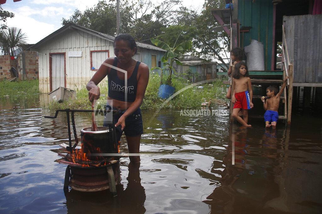 Edmar Barros Edileuza Pereira da Silva cooks for her family outside her home, flooded by the rise of the Negro river in Iranduba, Amazonas state, Brazil, Monday, May 23, 2022. The Amazon region is being hit hard by flooding with 35 municipalities that are facing one of their worst floods in years and the water level is expected to rise over the coming months. (AP Photo/Edmar Barros)