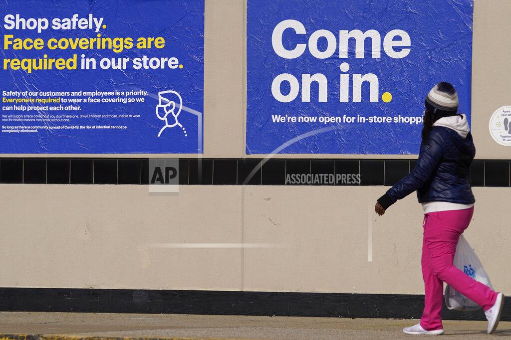 Nam Y. Huh A shopper walks to a retail store as information signs are displayed in Downers Grove, Ill., Sunday, Nov. 29, 2020. (AP Photo/Nam Y. Huh)
