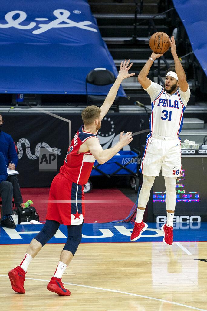 Philadelphia 76ers guard Seth Curry, right, shoots a three-pointer over Washington Wizards forward Davis Bertans, left, during the first half of an NBA basketball game, Wednesday, Jan. 6, 2021, in Philadelphia. (AP Photo/Chris Szagola)