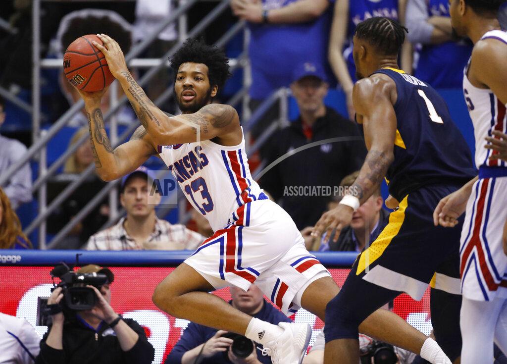 Colin E. Braley Kansas guard K.J. Lawson (13) rebounds the ball as West Virginia forward Derek Culver (1) defends during the second half of an NCAA college basketball game Saturday, Feb. 16, 2019, in Lawrence, Kan. (AP Photo/Colin E. Braley)