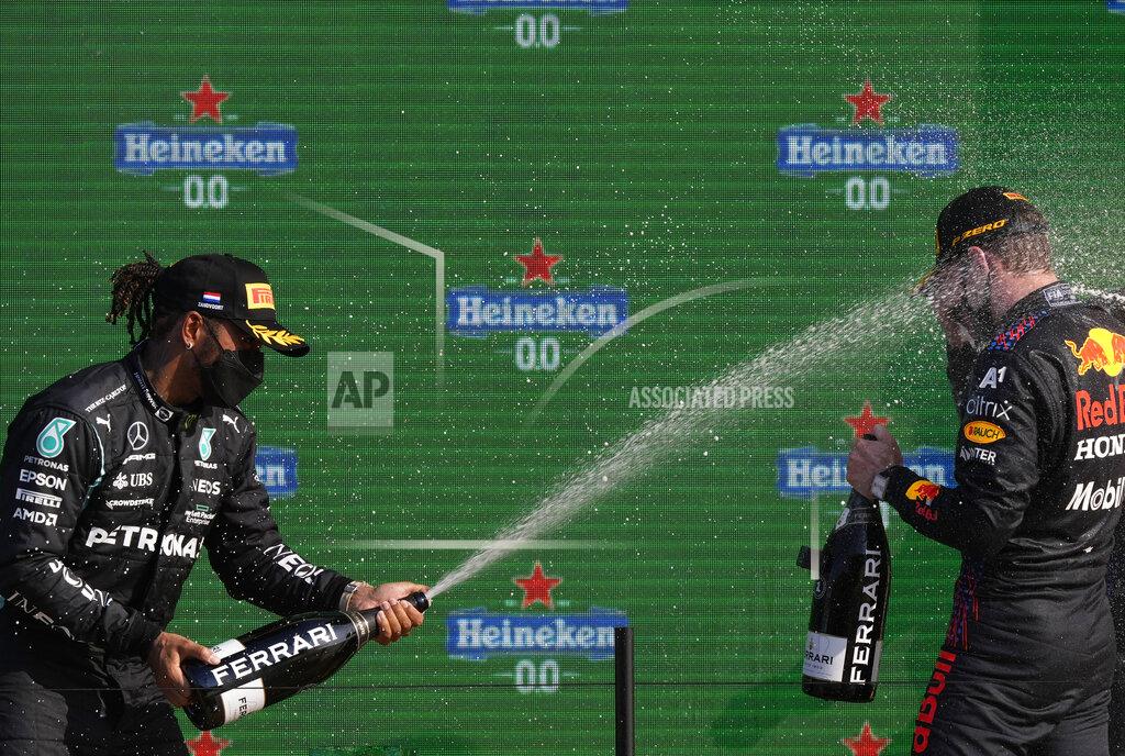 Peter Dejong Second placed Mercedes driver Lewis Hamilton of Britain, left, sprays champagne on a race winner Red Bull driver Max Verstappen of the Netherlands after the Formula One Dutch Grand Prix, at the Zandvoort racetrack, Netherlands, Sunday, Sept. 5, 2021. (AP Photo/Peter Dejong)