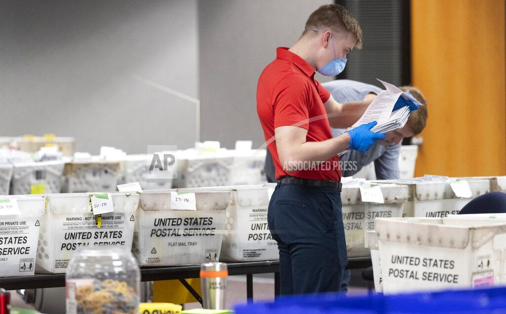 A City of Milwaukee Election Commission worker processes and sorts absentee ballots for Tuesday's primary election, Wednesday, April 8, 2020, in downtown Milwaukee, Wis. (Mark Hoffman/Milwaukee Journal-Sentinel via AP)