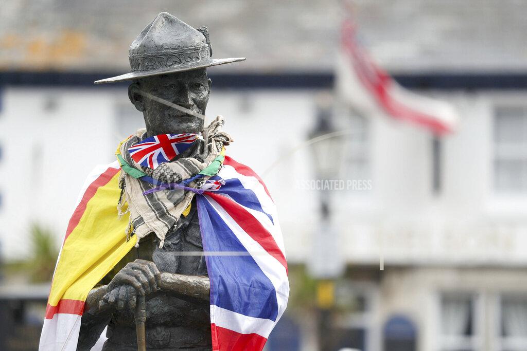 Andrew Matthews A Dorset flag, left, and a British flag wrap a statue of Robert Baden-Powell on Poole Quay in Dorset, Britain, Friday June 12, 2020. Officials plan to remove a statue of the founder of the Scouts movement from the quayside in Poole, southern England, out of concern it may be a target for protests ignited by the death of George Floyd, who died after he was restrained by Minneapolis police on May 25. (Andrew Matthews/PA via AP)