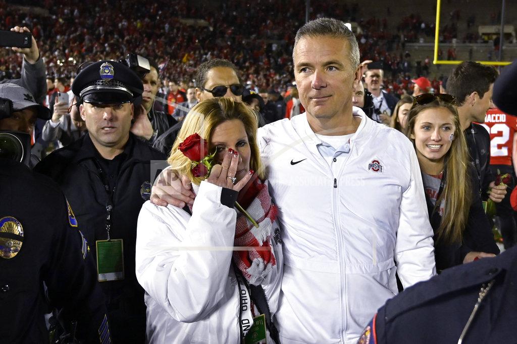 Mark J. Terrill Ohio State coach Urban Meyer and his wife, Shelley, left, leave the field after Ohio State defeated Washington 28-23 in the Rose Bowl NCAA college football game Tuesday, Jan. 1, 2019, in Pasadena, Calif. (AP Photo/Mark J. Terrill)