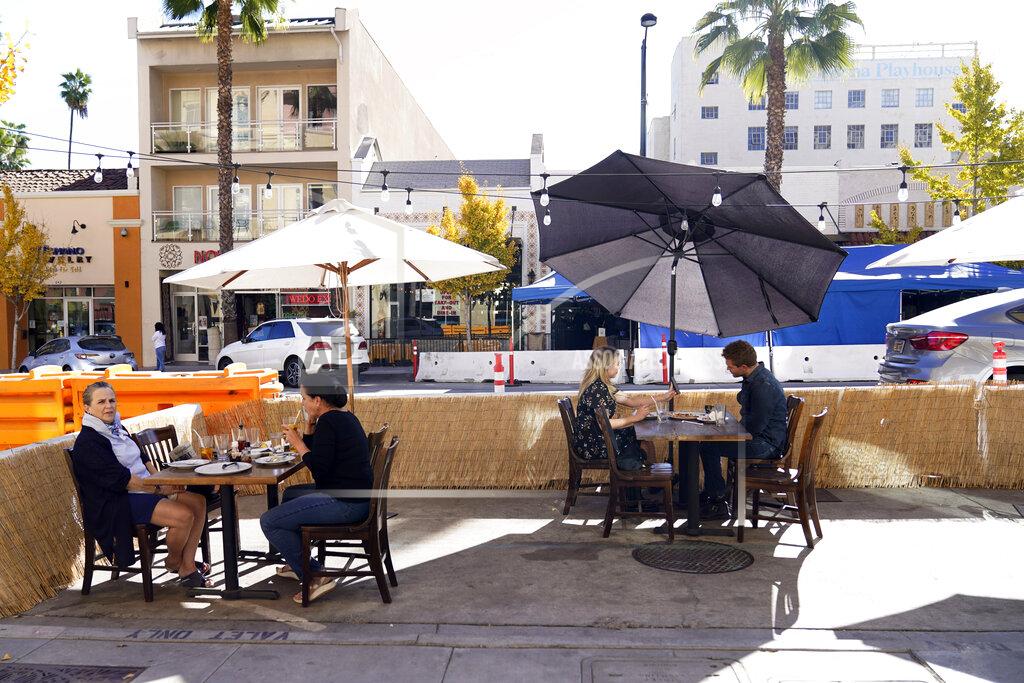 Marcio Jose Sanchez *** Hold For Story *** Patrons eat lunch outside of Settebello Pizzeria Napoletana Tuesday, Dec. 1, 2020, in Pasadena, Calif. Pasadena has become an island in the center of the nation's most populous county, where a surge of COVID-19 cases last week led to a three-week end to outdoor dining and California's first stay-home order since the pandemic began to spread across the state in March. (AP Photo/Marcio Jose Sanchez)