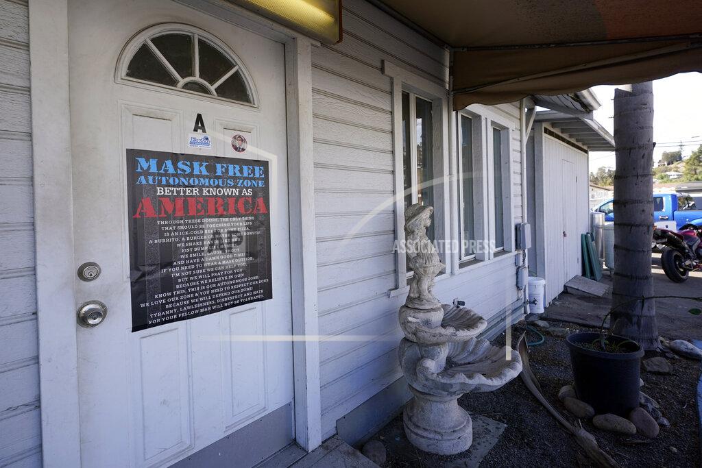 Gregory Bull A sign against wearing masks to slow the spread of the coronavirus covers the office door of Fowler's Pool Services and Supply Inc, Thursday, Jan. 7, 2021, in Spring Valley, Calif. Authorities have identified the woman who was fatally shot inside the Capitol building on Wednesday as Ashli Babbitt, listed as an owner of Fowler's. According to family and her social media accounts, she was an Air Force veteran and avid supporter of President Donald Trump and his efforts to stay in office. Capitol Police say the shooting occurred as thousands of rioters forced their way into the House chamber, where members of Congress were hiding. (AP Photo/Gregory Bull)