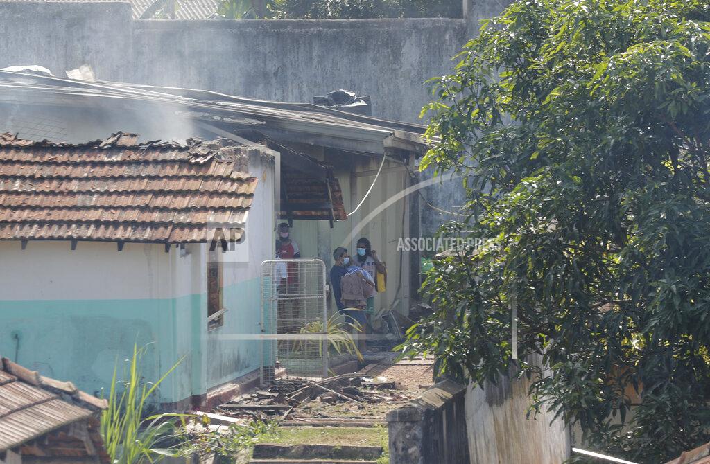 Eranga Jayawardena A Sri Lankan inmate of the Mahara prison carries a fellow inmate out from a damaged building as others watch following an overnight unrest in Mahara, outskirts of Colombo, Sri Lanka, Monday, Nov. 30, 2020. Sri Lankan officials say six inmates were killed and 35 others were injured when guards opened fire to control a riot at a prison on the outskirts of the capital. Two guards were critically injured. Pandemic-related unrest has been growing in Sri Lanka's overcrowded prisons. (AP Photo/Eranga Jayawardena)